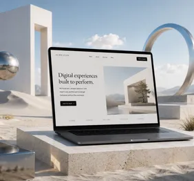 Laptop showing a website mockup in a minimal architectural setting