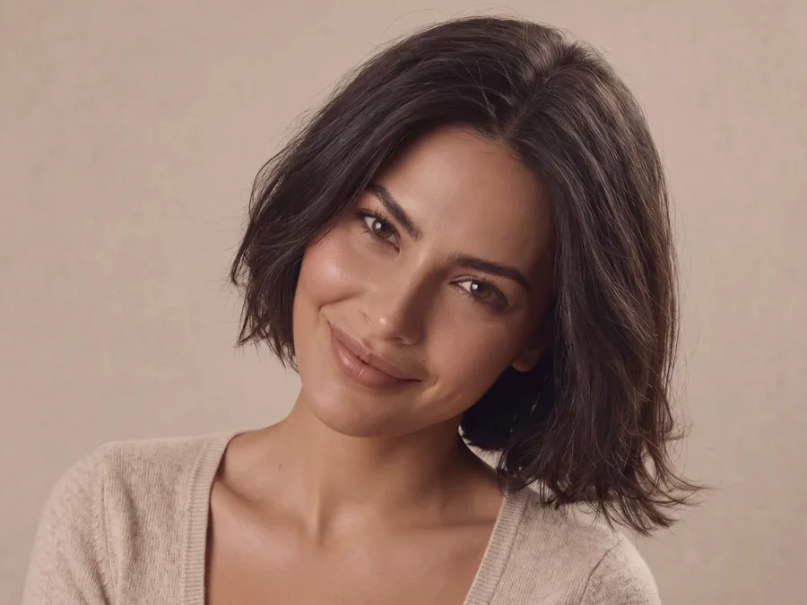 Close-up portrait of an AI fashion model in a beige knit top